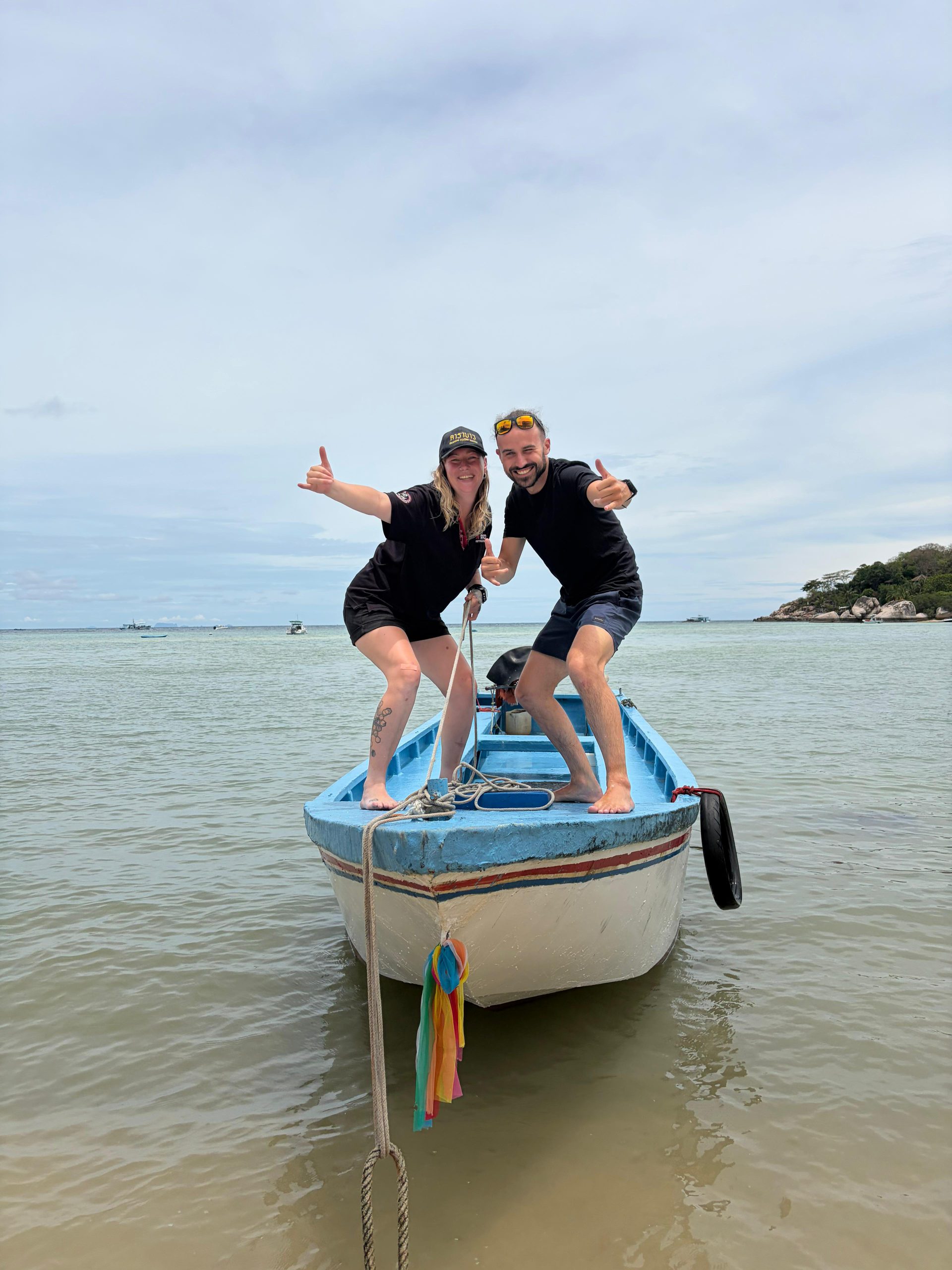 Carabao divemasters and divers grinning on the boat after a dive, Koh Tao