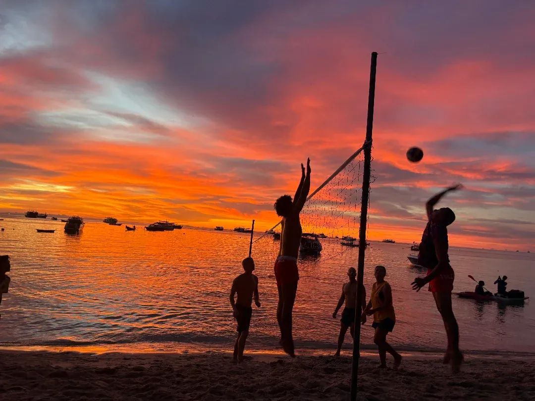 Beach volley in controluce contro un tramonto infuocato su Chalok Bay al Carabao Diving Resort, Koh Tao